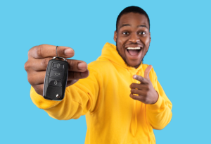 A person wearing a yellow hoodie showing their new va rkeys to the camera in front of a light blue background near Ontario, California